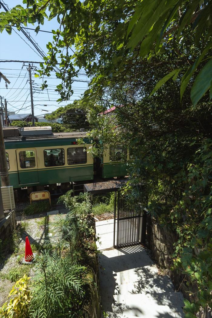 敷地の入口階段の目の前を通過する江ノ電